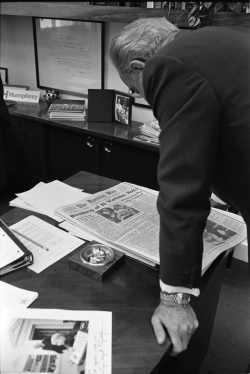 President Lyndon B. Johnson reading newspaper headline re bombing halt