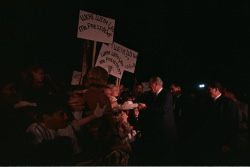 Supporting the Vietnam War: President Lyndon B. Johnson shakes hands with crowd, some carrying signs of support for LBJ